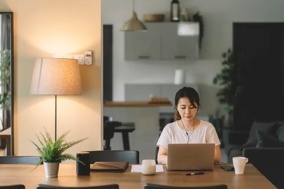 A woman sitting in a cafe working from her laptop